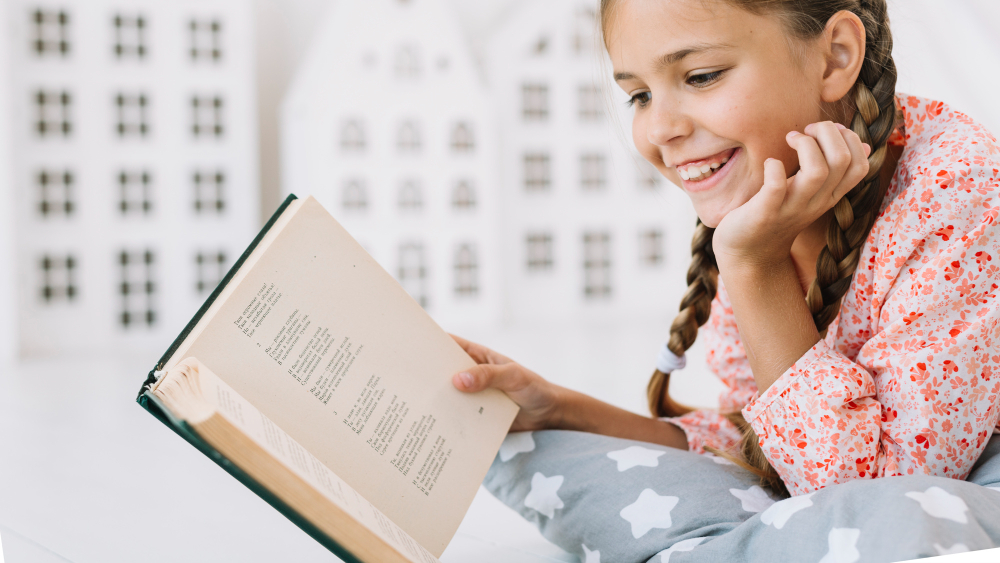 Happy child reading a colourful book